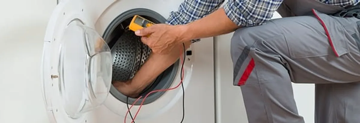 Dryer repair technician inspecting and repairing a clothes dryer in Indianapolis, IN