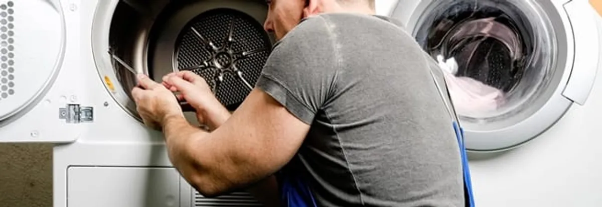 Dryer repair technician fixing a clothes dryer drum in Indianapolis, IN