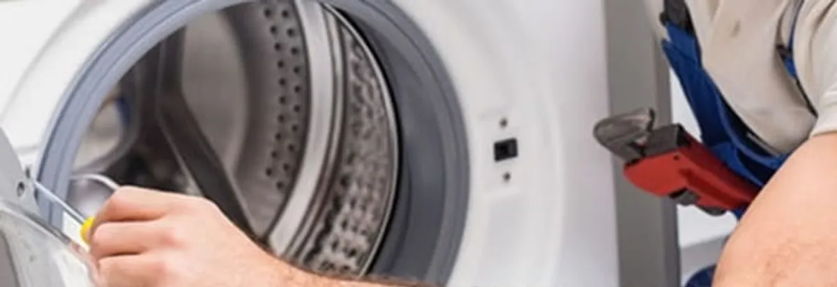 Appliance technician repairing a clothes dryer drum and internal parts in Indianapolis, IN