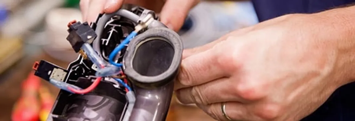 Vacuum repair technician reconnecting wiring and components in Indianapolis, IN